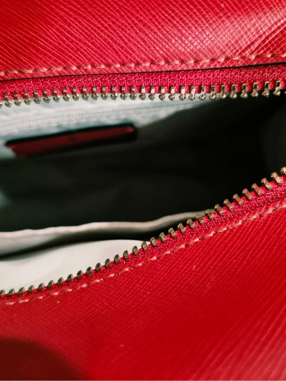 This red satchel is a Kate Spade New York Madison Saffiano Leather